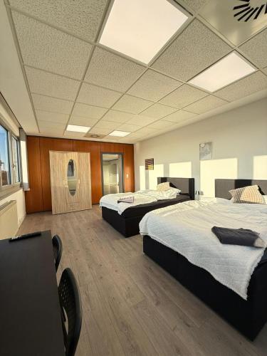 レムシャイトにあるFerienwohnung Remscheid UHFの木製の床がある広い部屋にベッドが2つあります