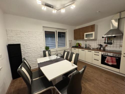 a kitchen and dining room with a white table and chairs at Urlaub mit Bergblick - Ferienhaus in Bad Bleiberg in Bad Bleiberg