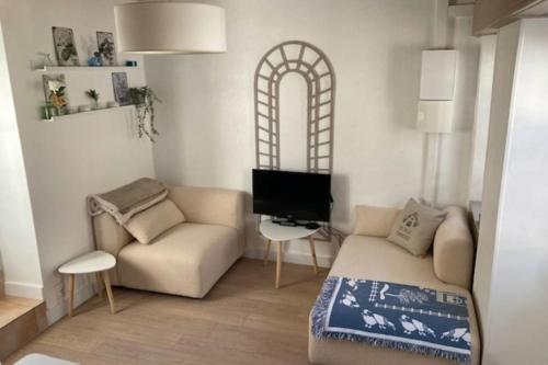 a living room with a couch and a chair at Maison de famille proche du château et grande terrasse-jardin in Pornic