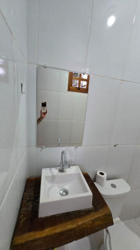 a white bathroom with a sink and a toilet at Rancho Petite Fleur in Aparecida do Taboado