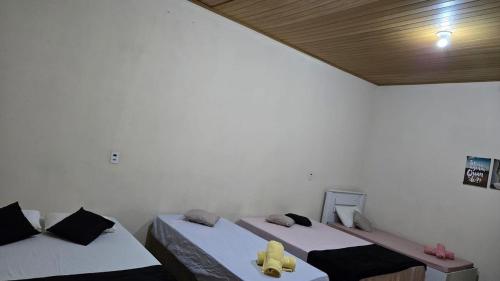 a room with two beds and a wooden ceiling at Rancho Petite Fleur in Aparecida do Taboado