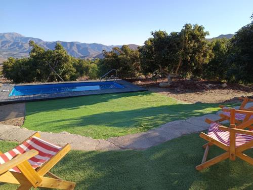a yard with two chairs and a swimming pool at Casa Mamalluca in Vicuña