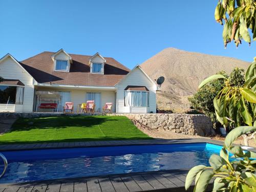 a house with a swimming pool in front of a mountain at Casa Mamalluca in Vicuña