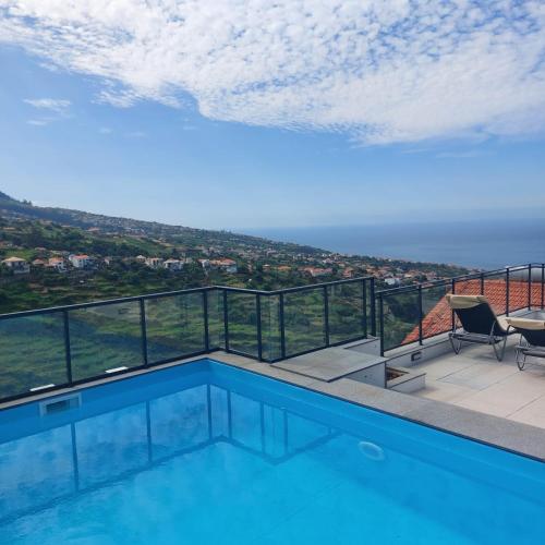 a swimming pool with a view of the ocean at Paradise Point Sea & Mountain view in Estreito da Calheta