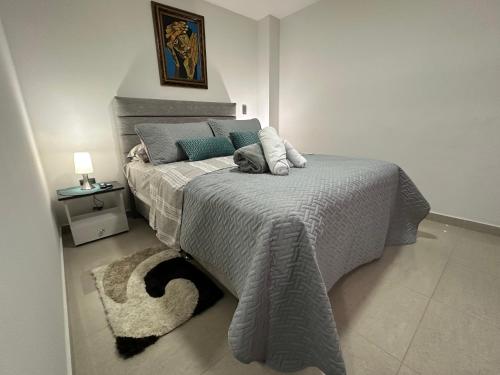 a bedroom with a bed with a gray blanket at Apartaestudios cerca centros comerciales in Ibagué
