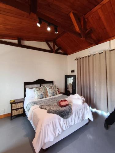 Un dormitorio con una cama grande en una habitación con techos de madera. en Oriebruggie Accommodation, en Calvinia