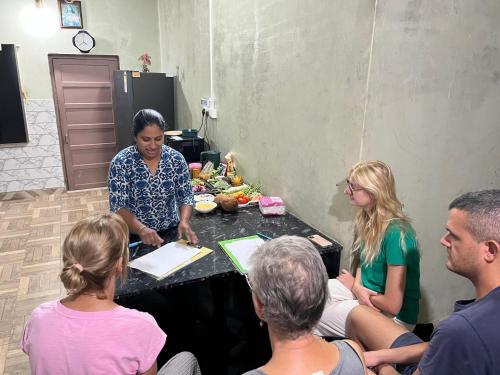 a group of people sitting around a table at Maliyeckal Homestay in Munnar