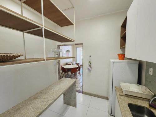 a kitchen with white cabinets and a table in it at Historico Edf Oceania in Boa Viagem in Recife