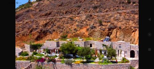 an aerial view of a house in front of a mountain at Aliori art caves in Aegiali