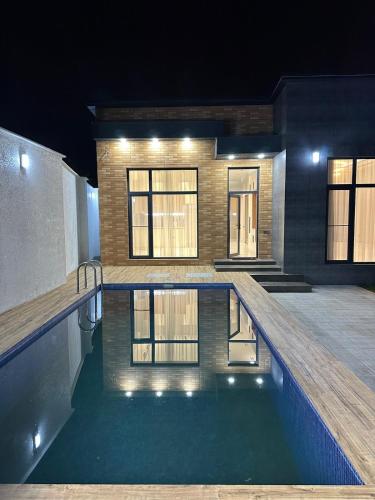 a house with a swimming pool at night at Cozy Modern Sunrise Beach Villa in Cǝnubi