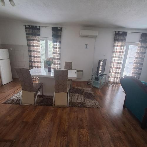 an empty living room with a table and chairs at Apartment Beha in Bihać