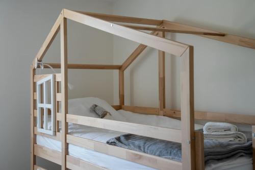 a bunk bed with a wooden frame and white sheets at Proche Puy duFou - Les Buardieres in Saint-Pierre-des-Échaubrognes
