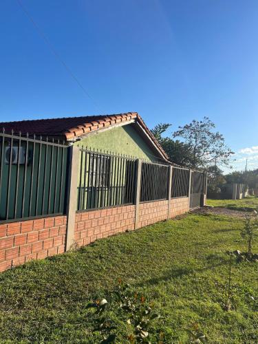 a fence in a yard next to a house at Casa Florida a 15 minutos de Encarnación in Encarnación