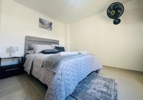 a bedroom with a bed with a blue comforter at Apartamento 301 Edificio Natura 54 in Ibagué