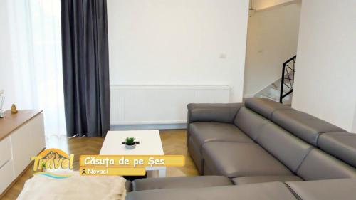 a living room with a couch and a table at Casuta de pe Ses in Novaci