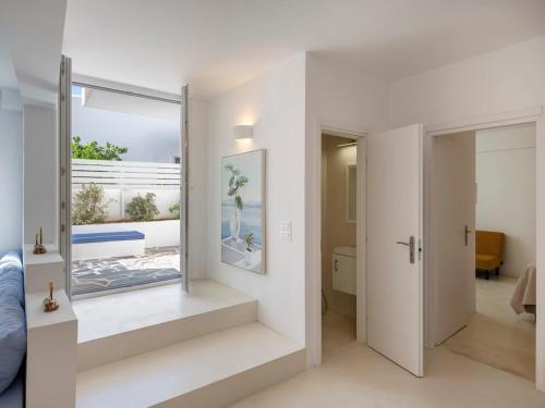 a bedroom with white walls and a door with a mirror at Casa De Tamara Paros in Kampos Paros