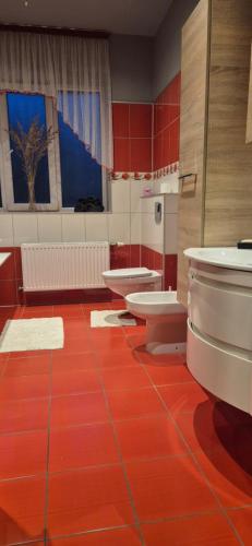 a bathroom with three sinks and red floor at Olesjas Apartamenti 