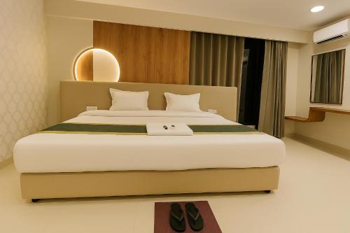 a bedroom with a large bed with shoes on it at Hotel Hill Park in Indore