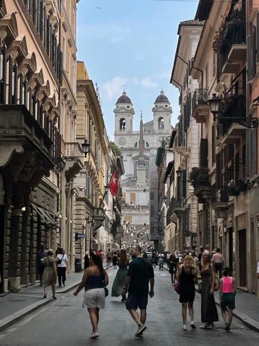 a group of people walking down a city street at carpe diem sistina in Rome