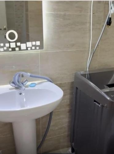 a bathroom with a white sink and a mirror at Ground peaceful chalet 3 bedroom with 6 king bed & 2 bathrooms &private garden marvelous land escape Murano resort Ain sokhna in Ain Sokhna