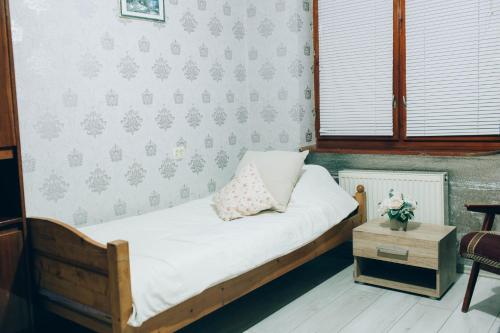 a small bedroom with a bed and a table at Standart - апартаменты рядом с термальными источникамм in Berehove