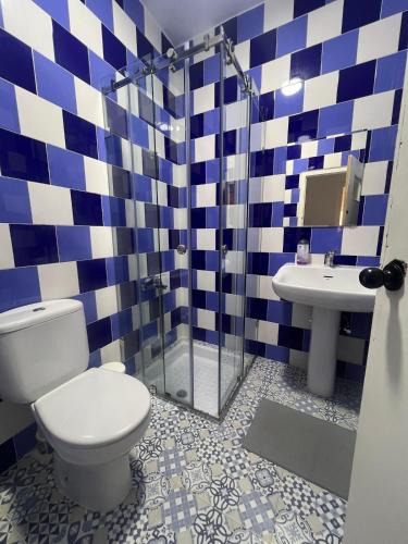 a blue and white bathroom with a toilet and a sink at Martil Concept in Martil