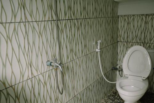 a bathroom with a shower with a toilet in it at Bukit Lawang - Batu Kapal Rimba House in Bukit Lawang