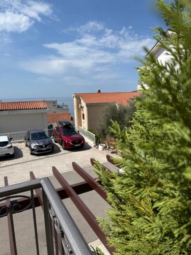 a balcony with a bench and cars parked in a parking lot at Apartments Petar in Budva