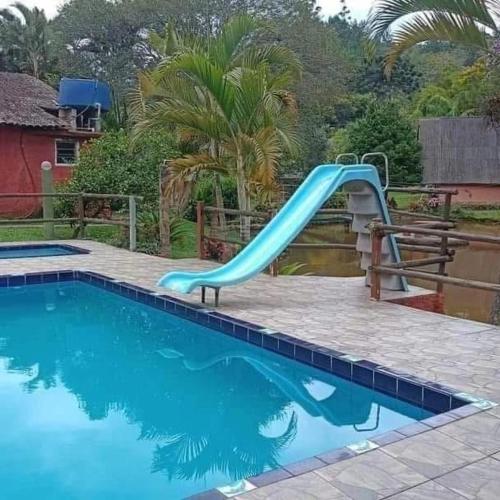 a blue slide in a swimming pool at Sítio Isolina Piscina, Campo e Lago in Juquitiba