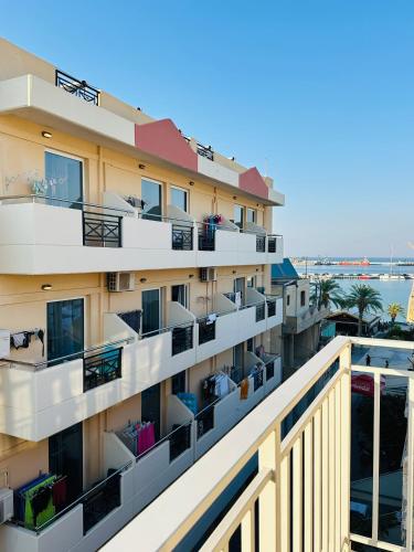 a building with balconies and the ocean in the background at SitiaHights Apartment in Sitia