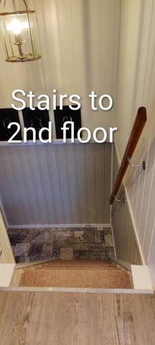 a stairs to floor with a wooden rail at Øya husrom-enkeltsenger-kjøkken-bad in Sarpsborg