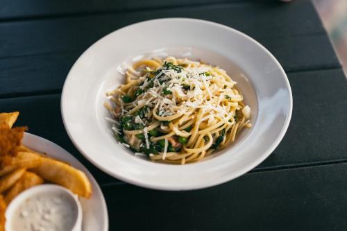 a bowl of pasta with cheese and greens on a table at MacTaverne in Val-David
