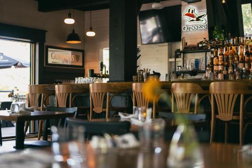 a bar in a restaurant with tables and chairs at MacTaverne in Val-David