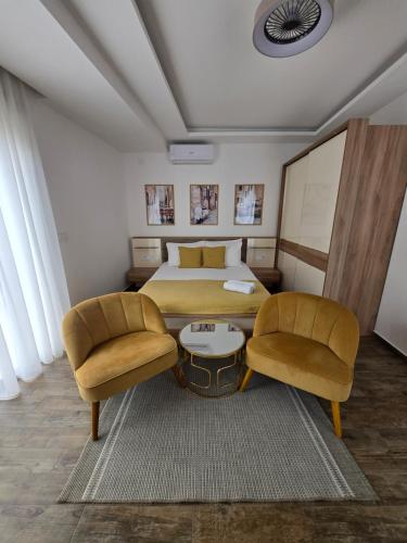 a hotel room with a bed and two chairs at Marea DeLuxe Apartments in Kotor