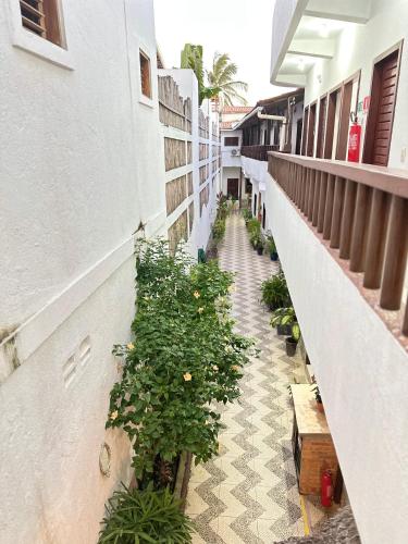 a corridor of a building with potted plants at Morada da Praia Pousada in Jericoacoara