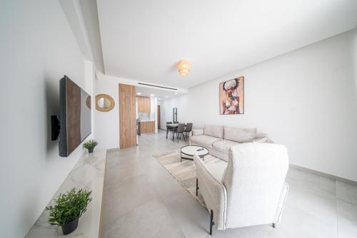 a living room with a couch and a table at Serene Gardens 2BR Stylish Apartment with Pool and Gym in Livadhia