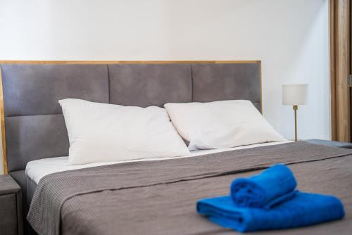 a bed with two blue towels on top of it at Serene Gardens 2BR Stylish Apartment with Pool and Gym in Livadhia