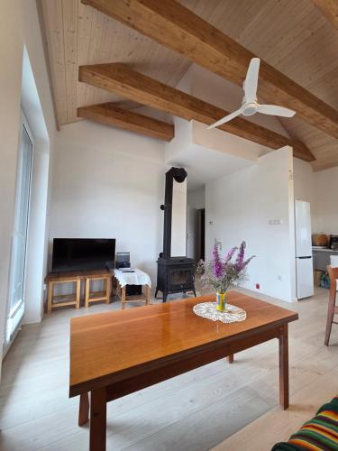 a living room with a wooden table and a fireplace at Oaza Spokoju in Wólka Iłowiecka