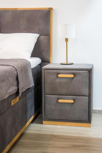 a bedroom with a bed with a nightstand with a lamp on it at Serene Gardens 2BR Stylish Apartment with Pool and Gym in Livadhia