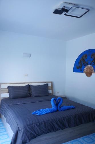 a bed with a blue comforter on top of it at Treff nad phop hotel in Patong Beach
