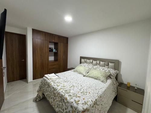 a bedroom with a bed and a wooden cabinet at Accommodation in Neiva in Neiva