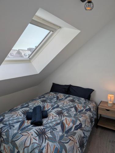 a bedroom with a bed and a window at Chaleureux T3 Duplex Centre - 10 min de la gare à pied in Quimper
