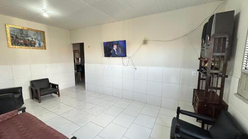 Zimmer mit einem Bett und einem Stuhl in der Unterkunft Casa de Temporadas Alto Bonito in Luis Correia