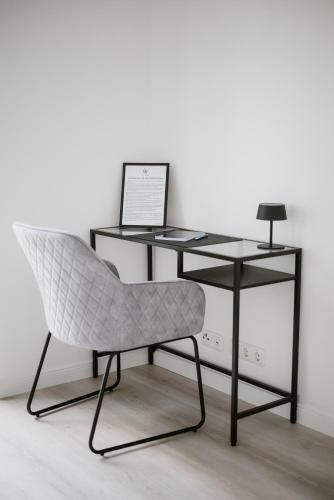 a desk with a chair and a laptop on it at Panorama-Seeblick, Privater Steg, Balkon, Parkplatz in Plön