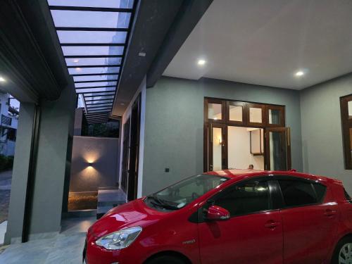 a red car parked in front of a house at Modern 4-Bedroom Home with Rooftop in Malabe in Malabe