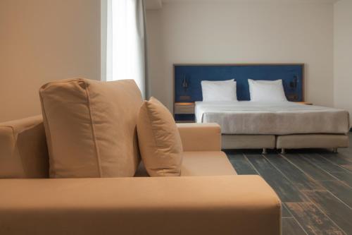 a living room with a couch and a bed at Shizen Wellness Hotel in Drama