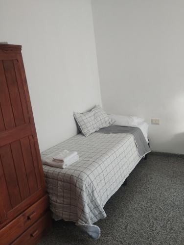 a small bedroom with a bed and a dresser at HTA Hospedaje Turismo Aventura in San Fernando del Valle de Catamarca