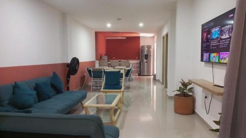 a living room with a blue couch and a kitchen at Casa Bacoba in Santa Marta
