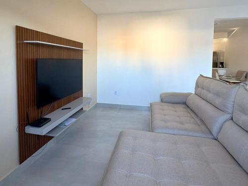 un soggiorno con divano e TV a schermo piatto di Oasis das Dunas a Cabo Frio