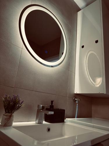a bathroom with a sink and a mirror at CityOasis Tuzla in Tuzla